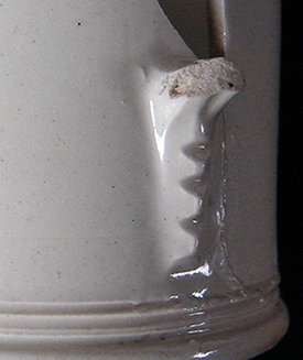 Mug with incised lathe turned decoration at base and rim. Handle terminal notched faceting detail – used by a number of Staffordshire potteries (Hilyard 2005 p. 41, 44).  Recovered from a well filled c. 1720s - c. 1750s, (Lots 2341, 2343).